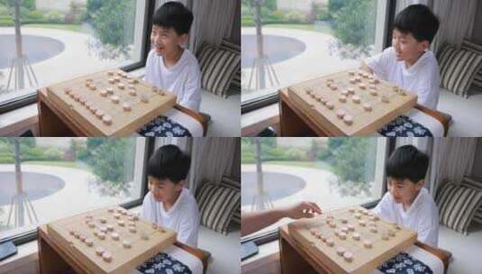 可爱的男孩在窗边下中国象棋高清在线视频素材下载