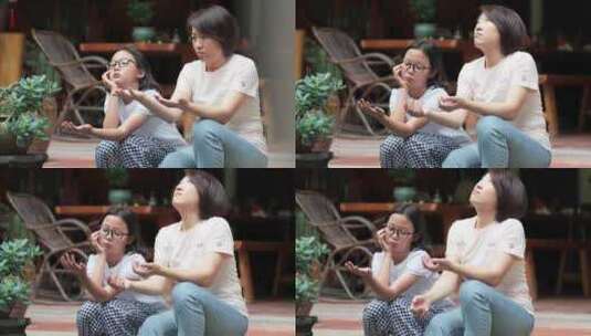 4K升格实拍坐在中式庭院纳台阶上聊天母女高清在线视频素材下载