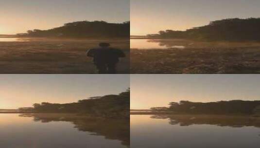 夕阳下男子独自走过湖边高清在线视频素材下载