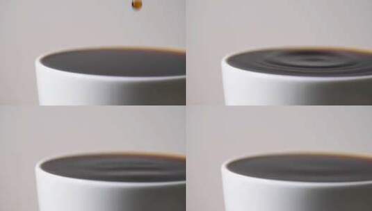 特写咖啡滴落到一杯咖啡的表面荡起层层涟漪高清在线视频素材下载