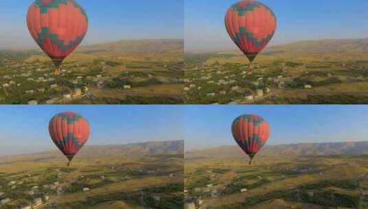 巨大的五彩热气球飞过亚美尼亚村庄，风景高清在线视频素材下载