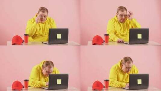 穿黄色衫的男子使用笔记本高清在线视频素材下载