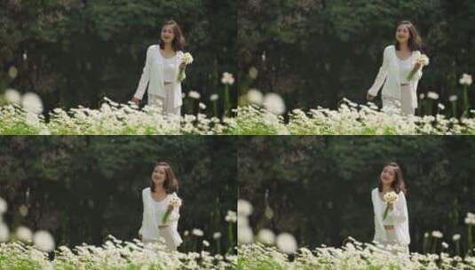 女青年拿着一束鲜花在春天草地散步慢镜头高清在线视频素材下载