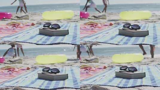 躺在海滩上的太阳镜、书籍、毛巾和海滩设备的视频高清在线视频素材下载