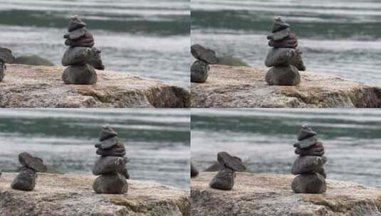 在海边一块巨石上堆叠的两个小石柱的缓慢跟踪镜头。高清在线视频素材下载