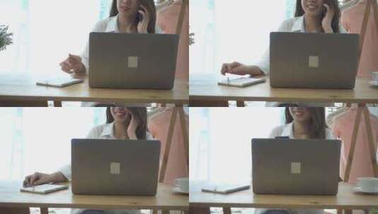 年轻微笑的亚洲女人坐在家里的客厅里打电话，一边用笔记本电脑工作。高清在线视频素材下载