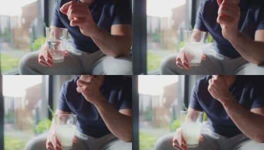 男子将钙与水一起放入玻璃杯的特写镜头高清在线视频素材下载