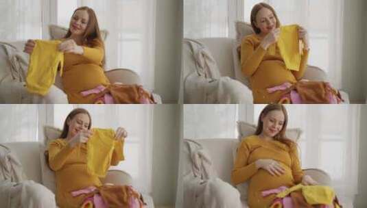 孕妇看着婴儿服装美丽的未来母亲享受分娩看高清在线视频素材下载