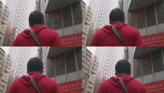 一个穿红衣服的男人走在香港街道上低角度拍摄高清在线视频素材下载
