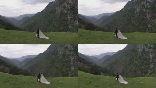 航拍在山脉中拍婚纱照的情侣高清在线视频素材下载