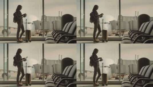 一个女人拿着登机文件站在窗外航站楼窗口高清在线视频素材下载