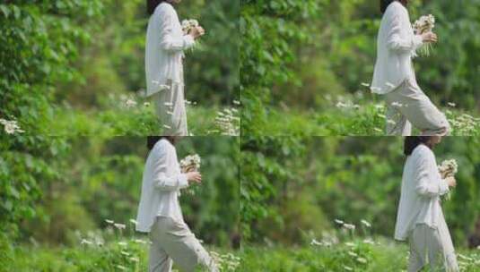 女青年拿着一束鲜花在春天草地散步慢镜头高清在线视频素材下载