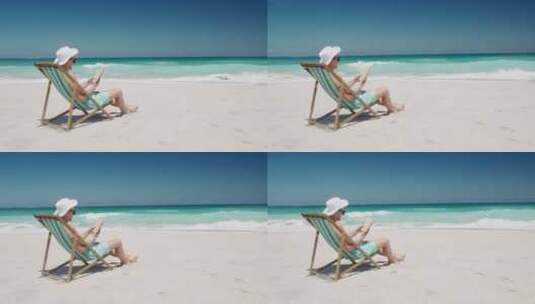 男子躺在海滩椅上看书高清在线视频素材下载