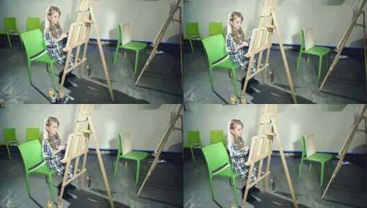 可爱的小女孩正在用画笔和油漆画画高清在线视频素材下载