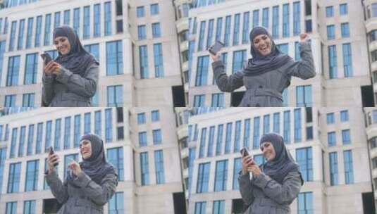 穆斯林女孩在电话上读到好消息后表现出是的手势，成功的职业生涯高清在线视频素材下载