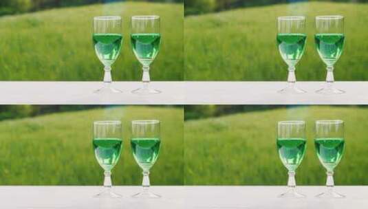 绿色草坪背景上的两杯绿色饮料高清在线视频素材下载