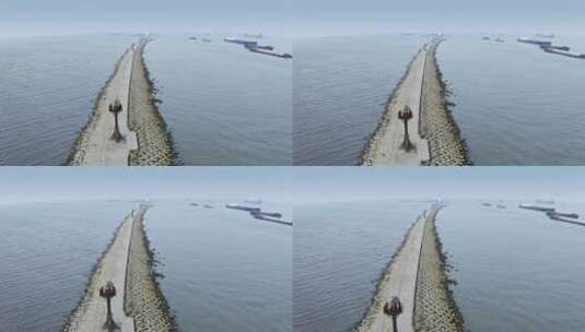 无人机视角航拍海岸堤坝小路与灯塔高清在线视频素材下载