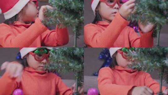 戴圣诞帽的小女孩正在装饰圣诞树高清在线视频素材下载