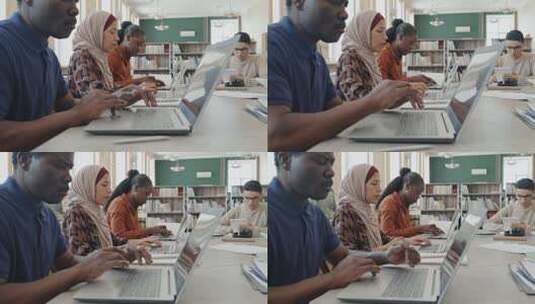 一群不同种族的学生坐在移民教育中心的桌子旁，上课时使用笔记本电脑高清在线视频素材下载