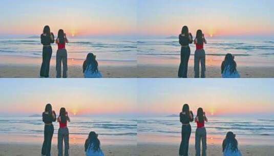 三个亚洲年轻漂亮美女站在大海边拍摄日出高清在线视频素材下载