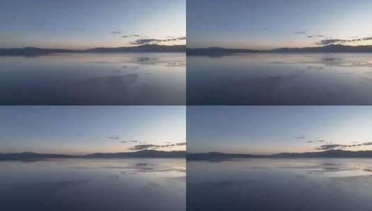 赛里木湖风平浪静的湖面倒映着美丽的朝霞高清在线视频素材下载