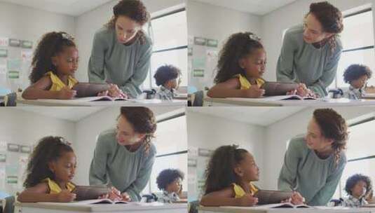 快乐的高加索女老师向拿着平板电脑的非裔美国女孩讲解课程的视频高清在线视频素材下载