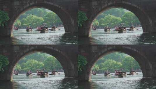 西湖游客乘坐游船经过石拱桥桥洞高清在线视频素材下载