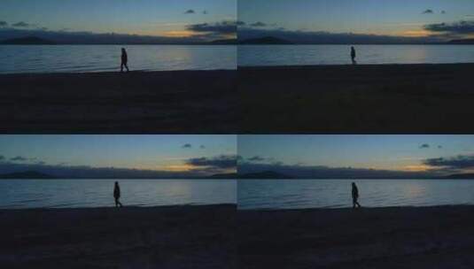 夕阳下一个人在海滩上行走剪影高清在线视频素材下载