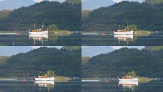 木船与小十二宫船航行在苏格兰的一个湖与森林和山脉在backgr高清在线视频素材下载