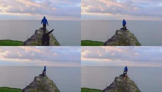 站立在悬崖上的人与狗高清在线视频素材下载