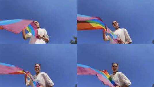 一名年轻女子在天空中升起彩虹旗高清在线视频素材下载