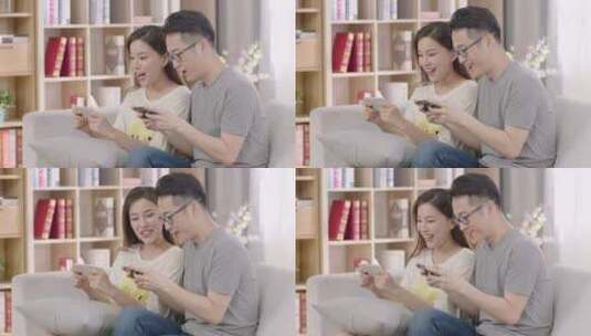 年轻夫妇在家中一起使用手机打游戏网购高清在线视频素材下载