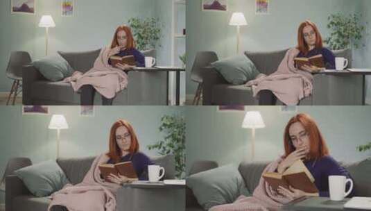红发女人坐在沙发上读有趣的书高清在线视频素材下载