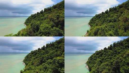 马来西亚槟城槟城国家公园森林中蓝色大海和茂密树木的鸟瞰图。高清在线视频素材下载