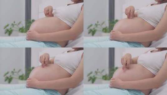 孕妇妈妈抚摸着自己的肚子期待宝宝出生高清在线视频素材下载