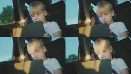 6岁白人女孩在车后座玩平板电脑高清在线视频素材下载