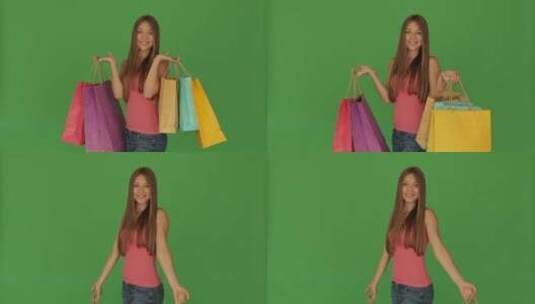 女孩提着购物袋在镜头前摆姿势高清在线视频素材下载