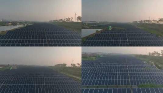 日出下的乡村里的太阳能光伏板和风力发电机高清在线视频素材下载