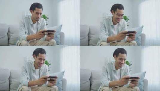 亚洲年轻英俊的男子玩家在家用智能手机玩手机游戏。高清在线视频素材下载