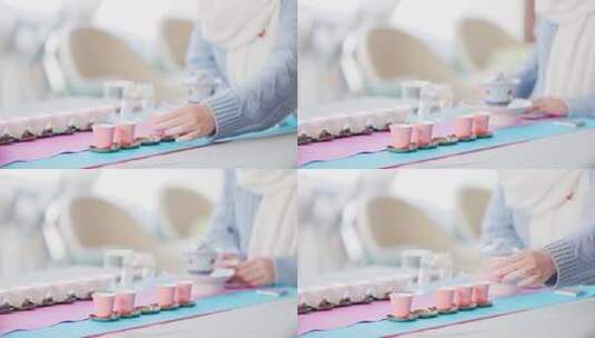 茶艺师拿起一个粉色茶杯高清在线视频素材下载