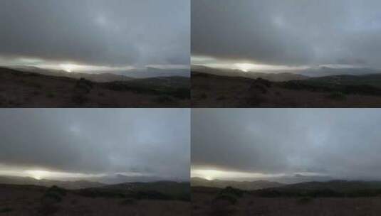 暴雨云层笼罩在黑暗的丘陵地带。高清在线视频素材下载