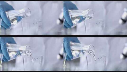 化学家从烧瓶中倒液体到玻璃杯中高清在线视频素材下载