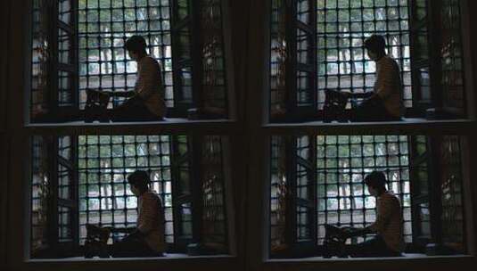 少年坐在窗户上的剪影高清在线视频素材下载