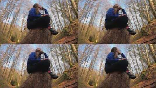一个女人坐在树墩上仰拍视角高清在线视频素材下载