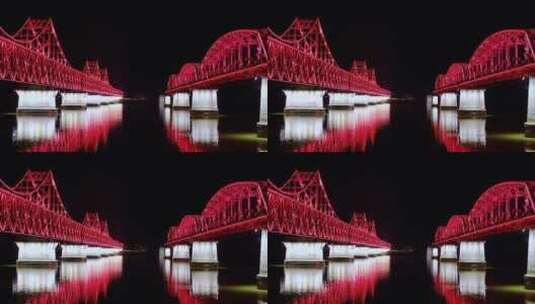 鸭绿江两座大桥夜晚红色灯光倒映在水面上高清在线视频素材下载