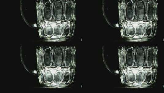 黑暗背景前的玻璃杯高清在线视频素材下载