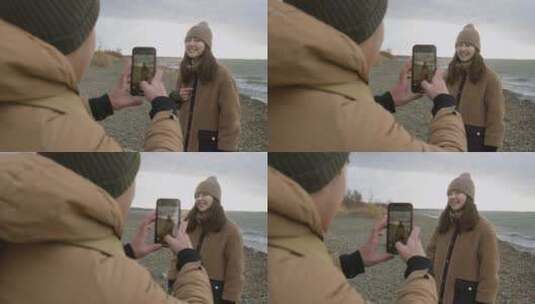 男人使用手机为女朋友拍照高清在线视频素材下载
