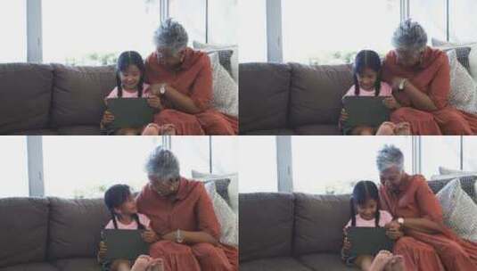 拿着平板电脑的出生女孩坐在祖母旁边，与复高清在线视频素材下载