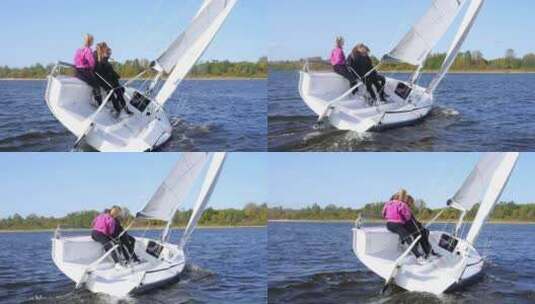 一个男人和两个女孩通过用脚控制帆来展示帆船的转弯高清在线视频素材下载