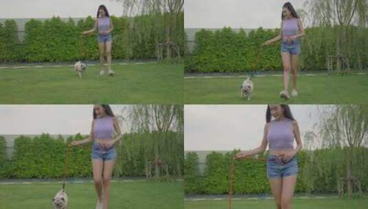 花园里带着哈巴狗散步的年轻女人高清在线视频素材下载